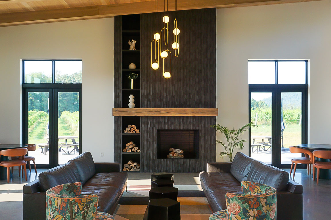 Black hinged doors with contemporary fixed windows overhead frame the walls of the lodge-style great room.