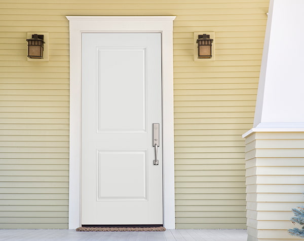 A white steel front door on a yellow-sided home exterior