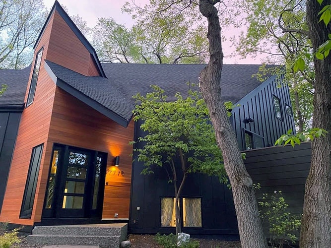 Front view of a modern home in Minnetonka with a newly installed black front door.