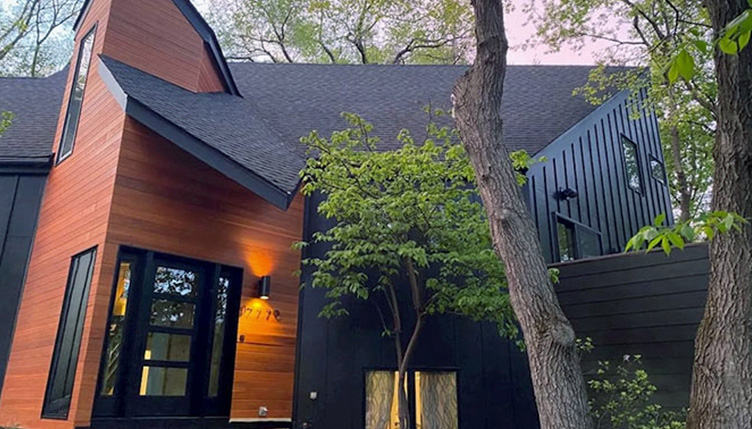 Front view of a modern home in Minnetonka with a newly installed black front door.