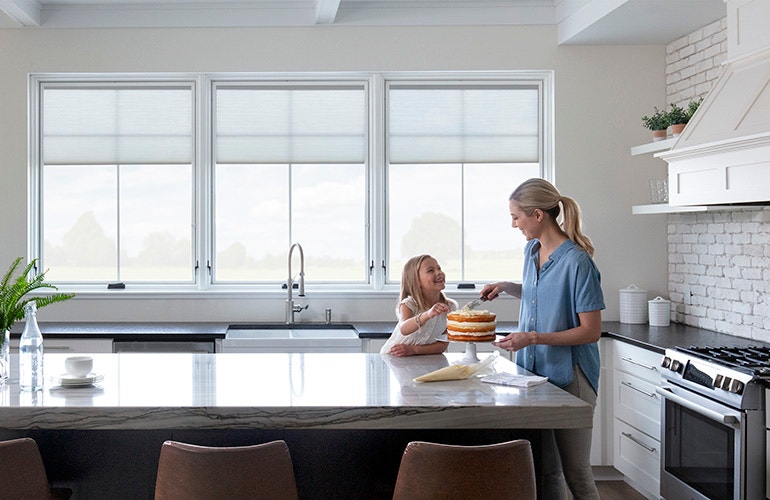 lifestyle windows in a kitchen with mom and daughter baking a cake