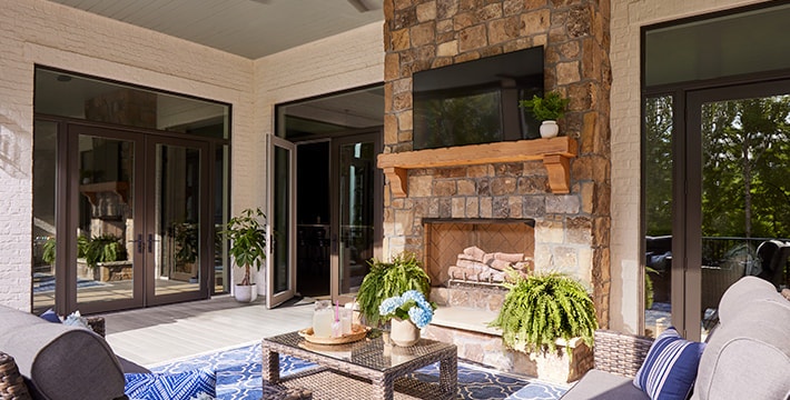 an outdoor patio with hinged and bifold doors framing the corner of the home wall