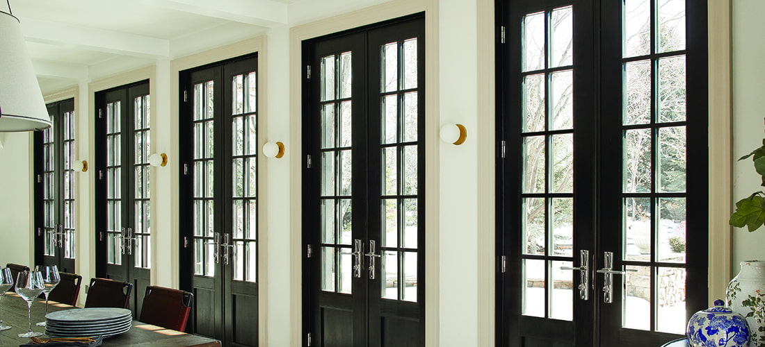 an outdoor patio with hinged and bifold doors framing the corner of the home wall