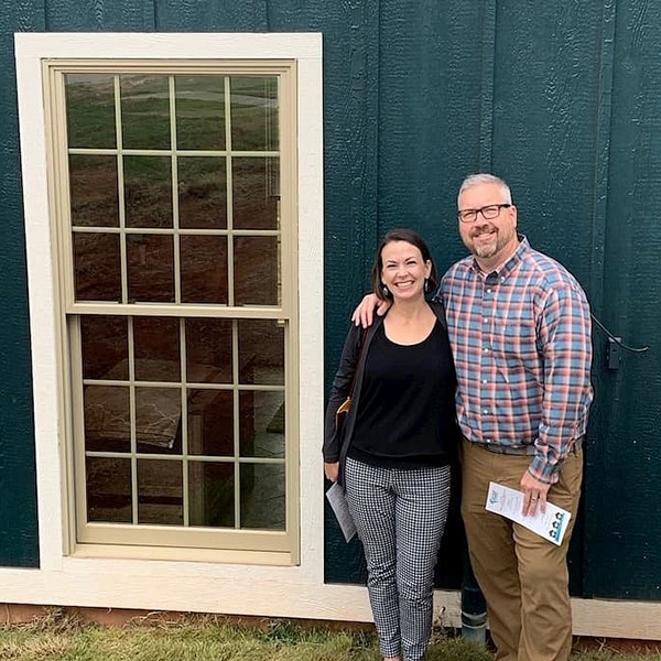 Andy and Ainslee Crum standing next to a Pella window on a tiny home
