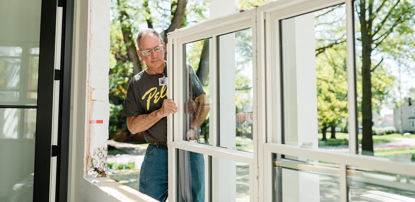 a pella employee installing a window into a pocket demonstrating pocket replacement