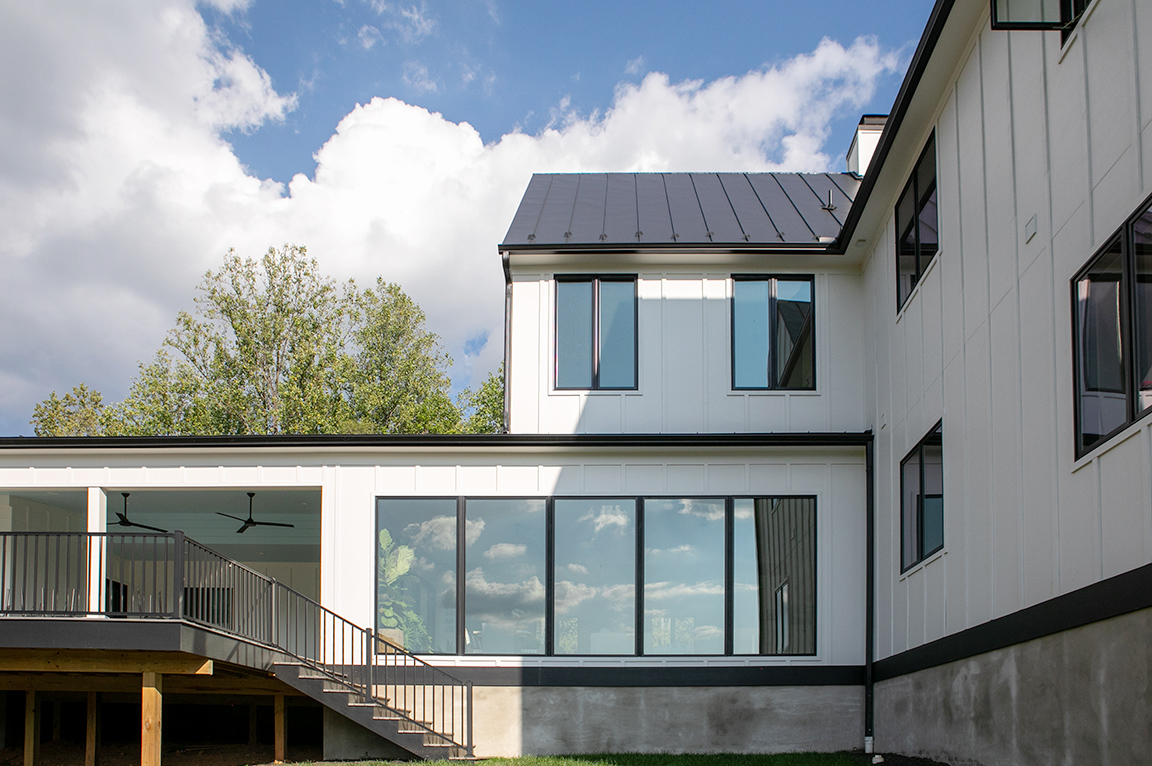 Exterior view of white modern farmhouse home with black windows in Free Union