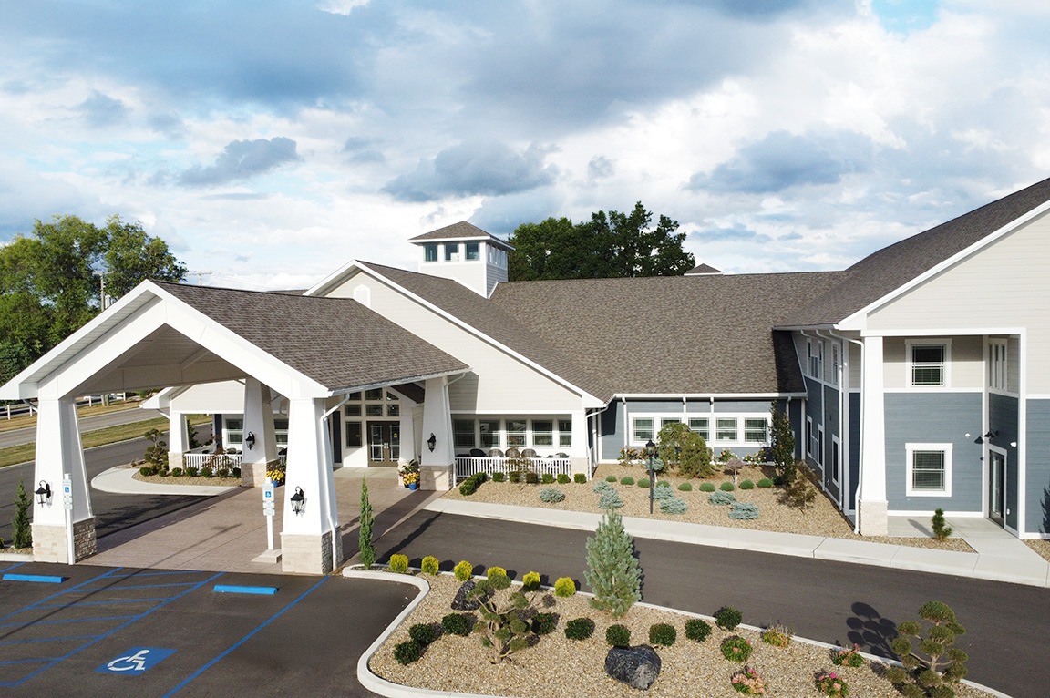 Main entrance of a commercial building with large windows and landscaped grounds.