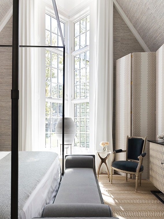 White bedroom windows with a traditional grille pattern and chic furniture.