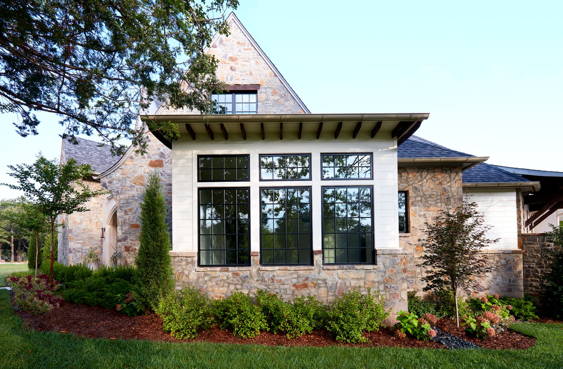 three large casement windows on the outside of a brick home