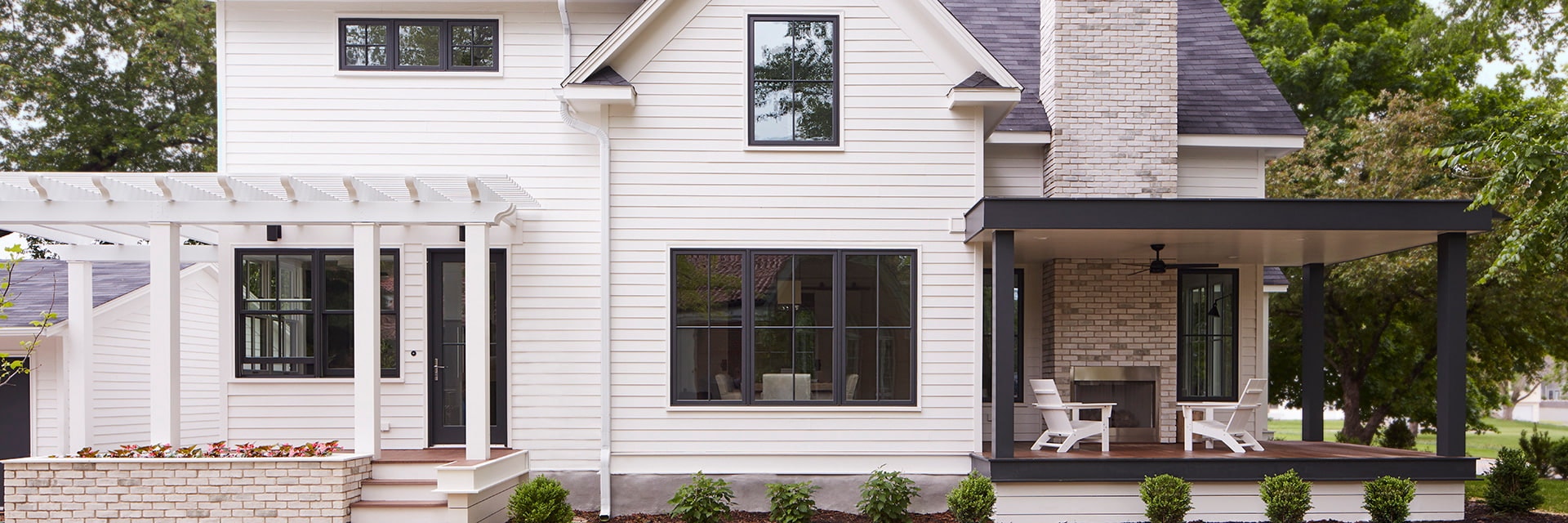 Exterior shot of white home with bold black windows and doors.