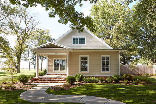 exterior shot of yellow home with cracked windows