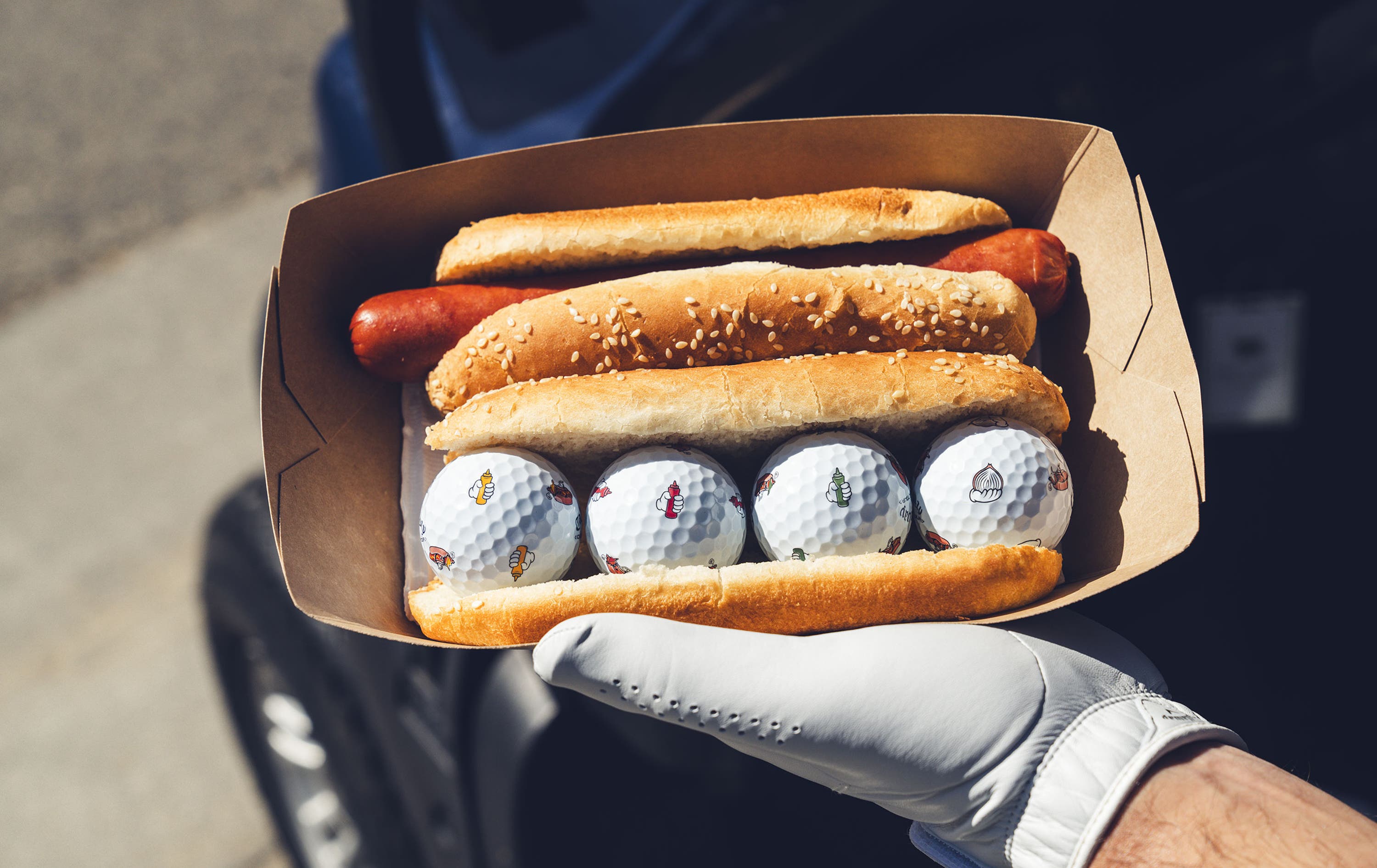 chrome tour golf balls with hot dog designs in a hot dog bun 