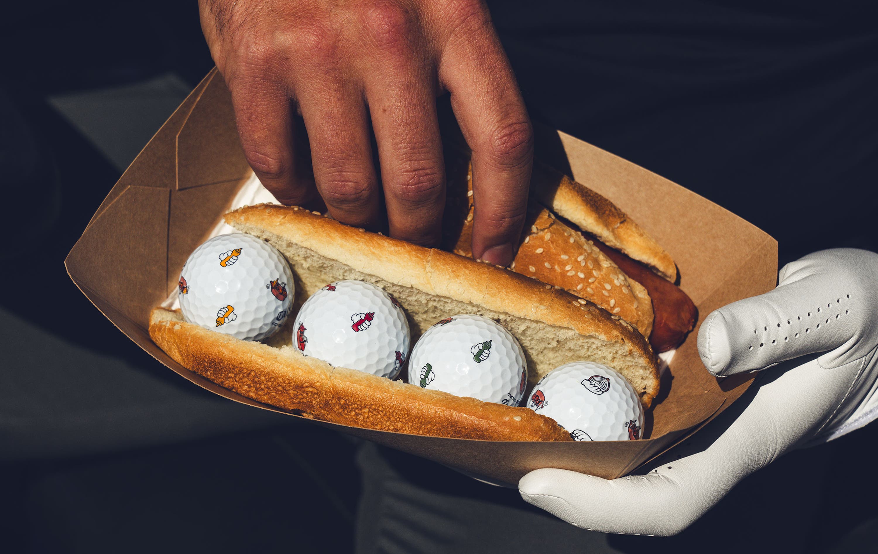 chrome tour golf balls with hot dog designs in a hot dog bun 