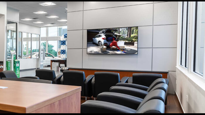 A photo of a waiting room playing Subaru TV Powered By LiveGuide®.