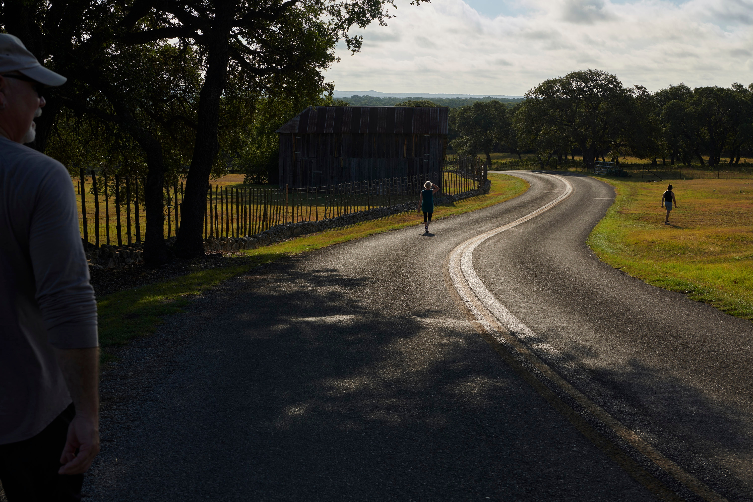 The photographer and her family walk along a winding road in Boerne Texas.