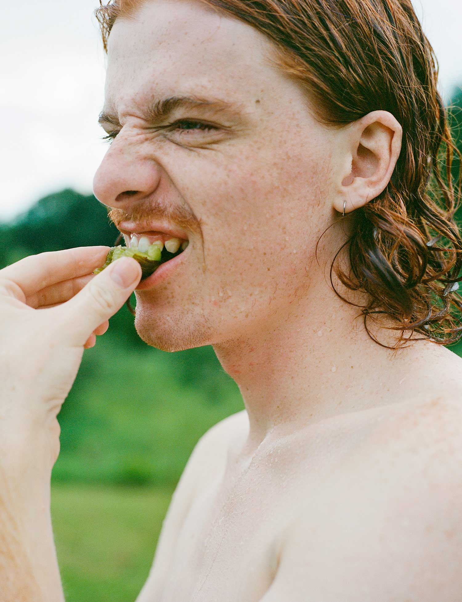 A person bites a tomato.