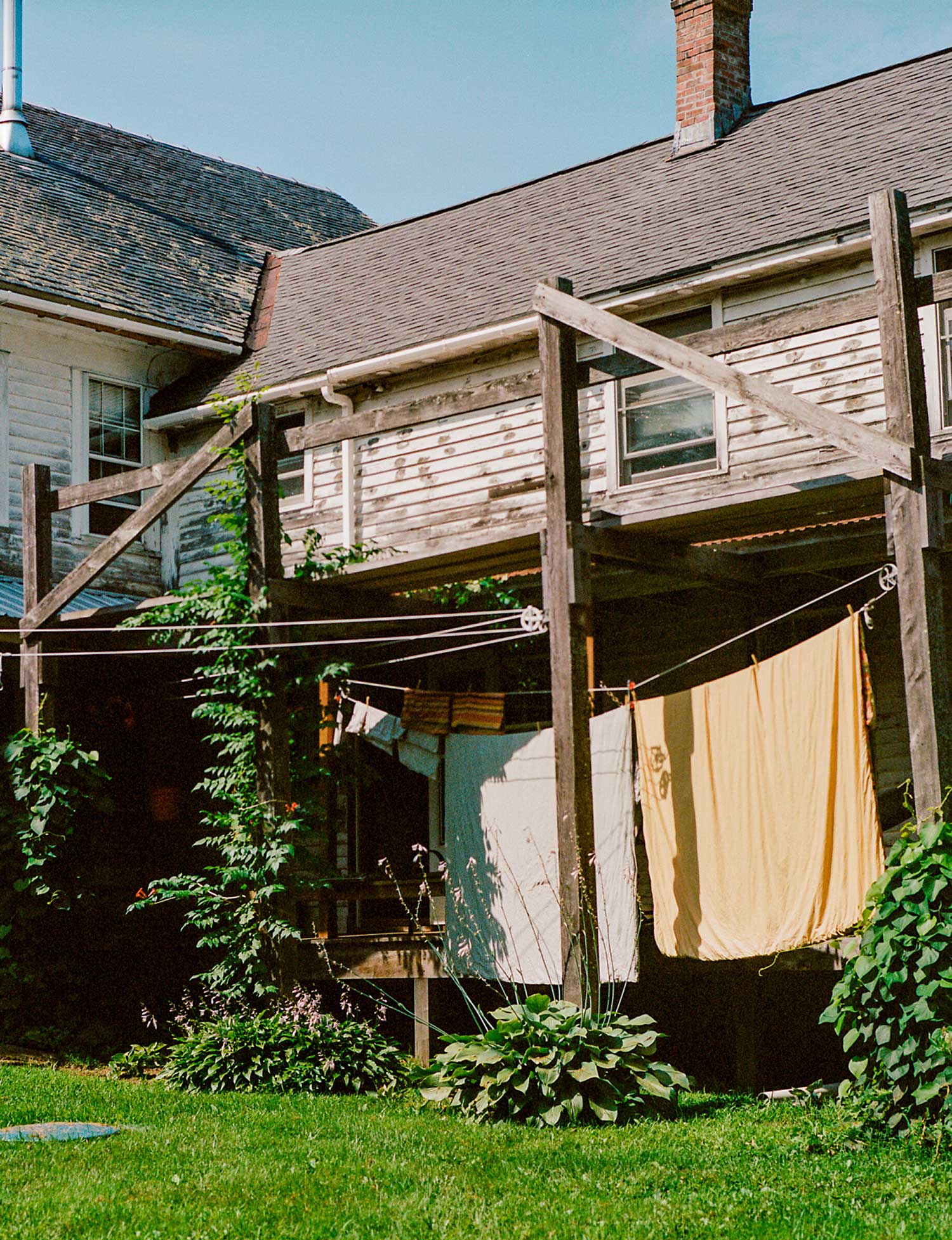 Laundry hangs along the exterior of an old, wooden house.
