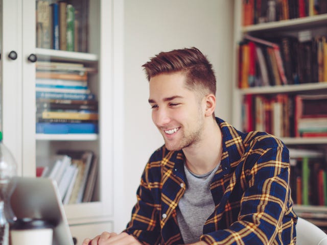 Młody mężczyzna uczęszczający na prywatny kurs angielskiego online w domu