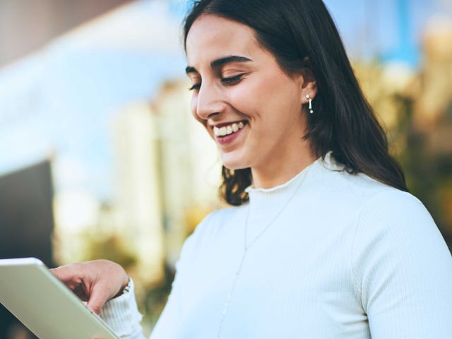 Kobieta wykorzystująca swój wolny czas na samodzielną naukę języka angielskiego na tablecie dzięki Berlitz Flex.