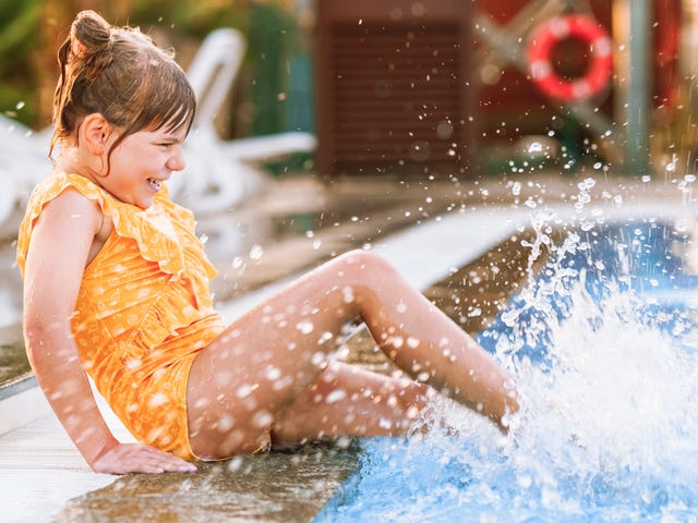 Dziecko uderzające nogami o taflę basenu znajdującego się w Łebie, gdzie odbywa się obóz językowy dla dzieci w Polsce