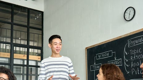 Grupa młodych dorosłych uczy się języka japońskiego w sali lekcyjnej.