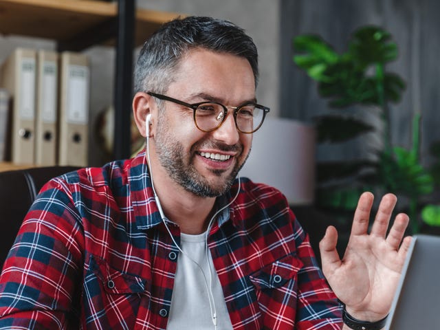 Mężczyzna machający do swojego nauczyciela języka angielskiego podczas prywatnego kursu językowego