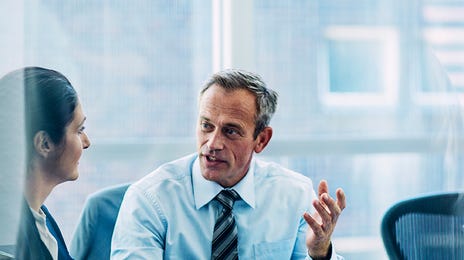 Kobieta i mężczyzna w biurze, rozmawiający po niemiecku o ważnych sprawach.