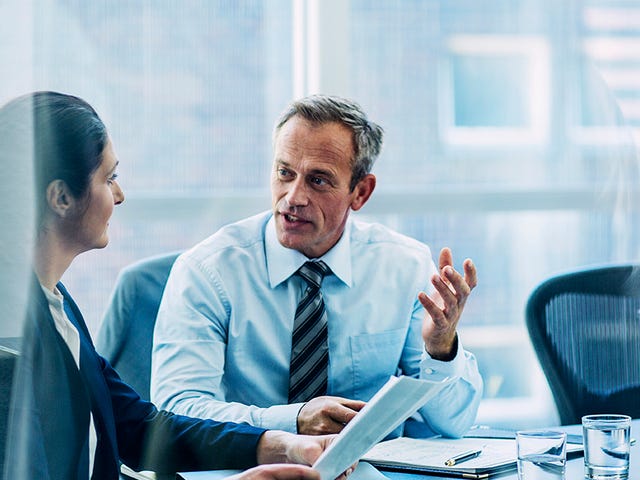 Kobieta i mężczyzna w biurze, rozmawiający po niemiecku o ważnych sprawach.