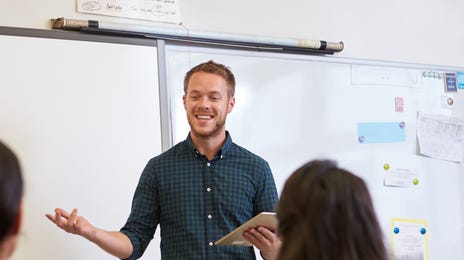 Entuzjastyczny lektor prowadzi zajęcia z języka japońskiego w sali lekcyjnej.