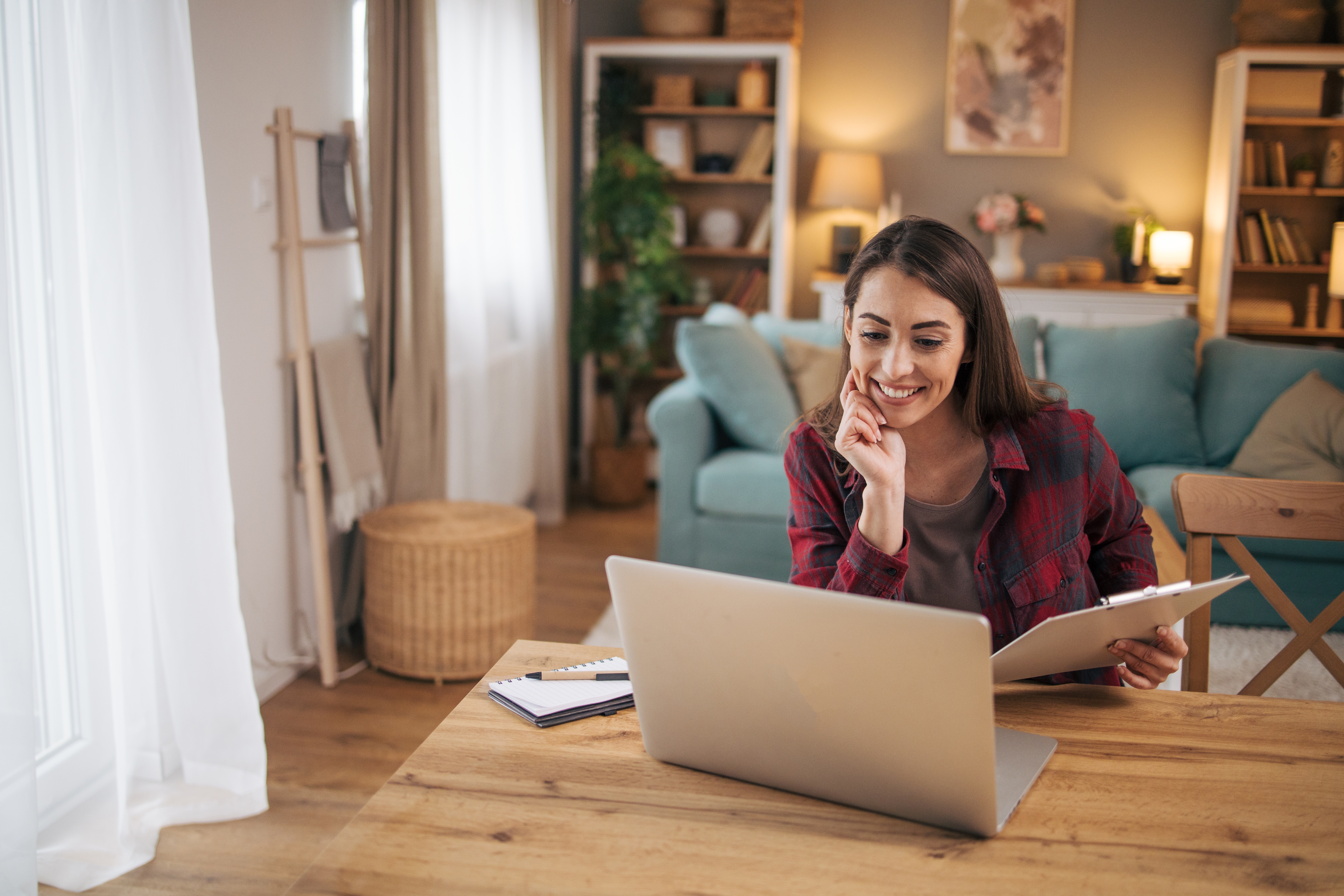Kobieta robiąca notatki podczas internetowego kursu języka angielskiego dla dorosłych.