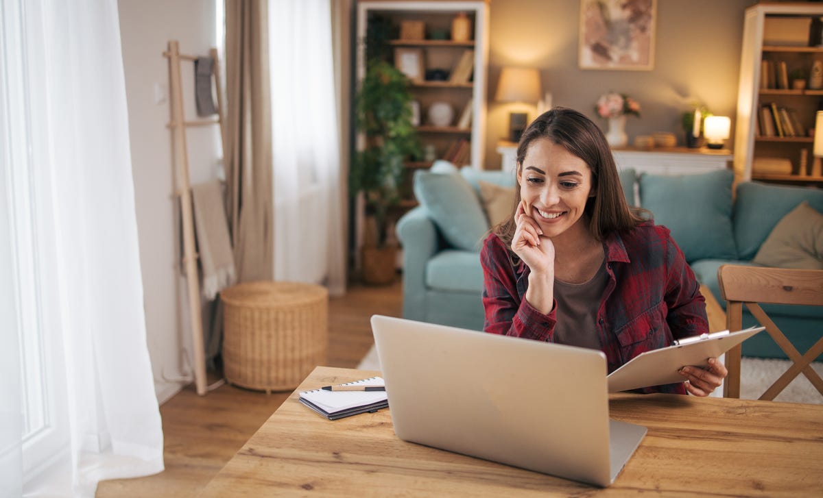 Kobieta robiąca notatki podczas internetowego kursu języka angielskiego dla dorosłych.