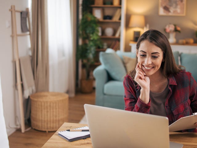 Kobieta robiąca notatki podczas internetowego kursu języka angielskiego dla dorosłych.