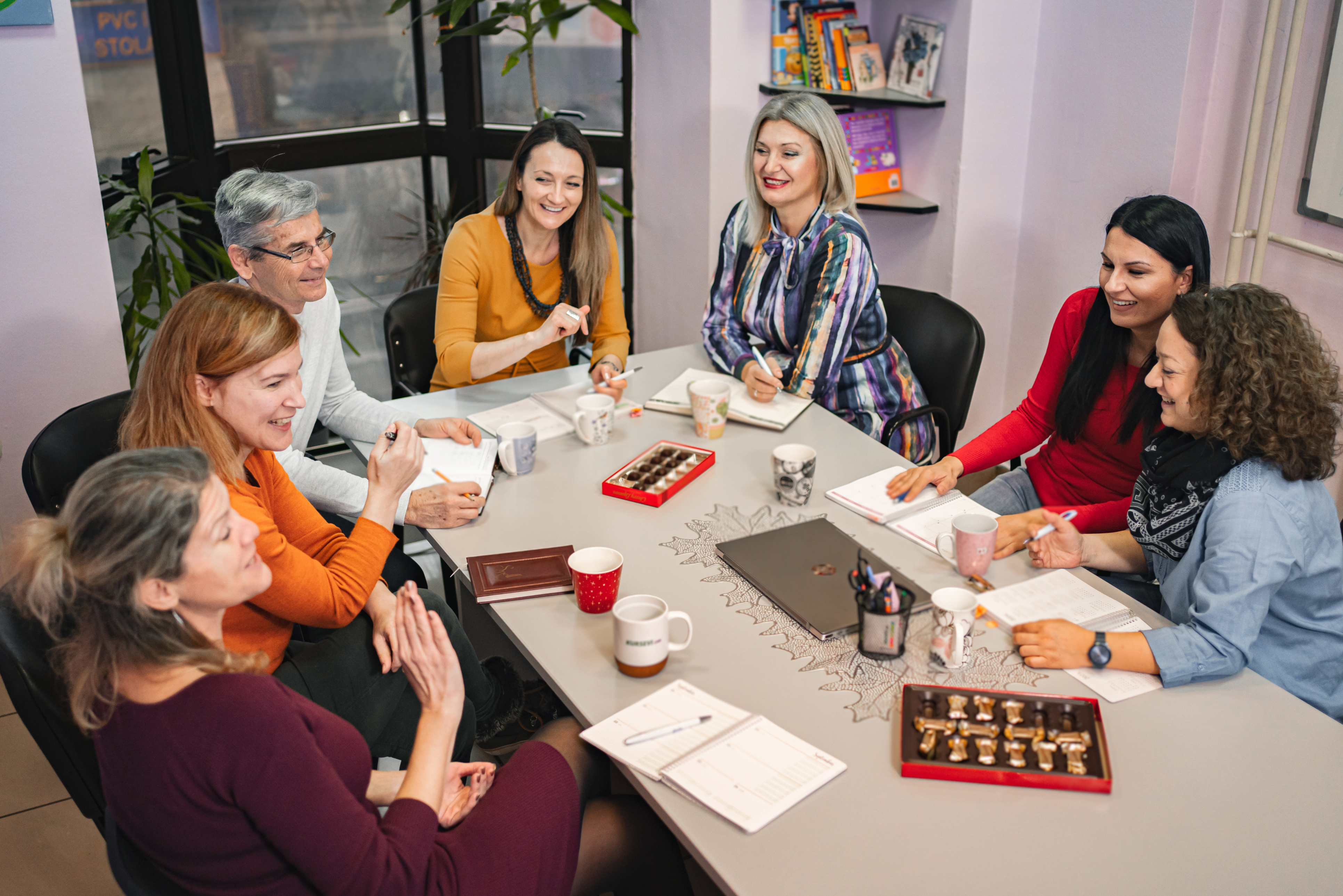 Grupa uśmiechniętych dorosłych uczy się wspólnie włoskiego 