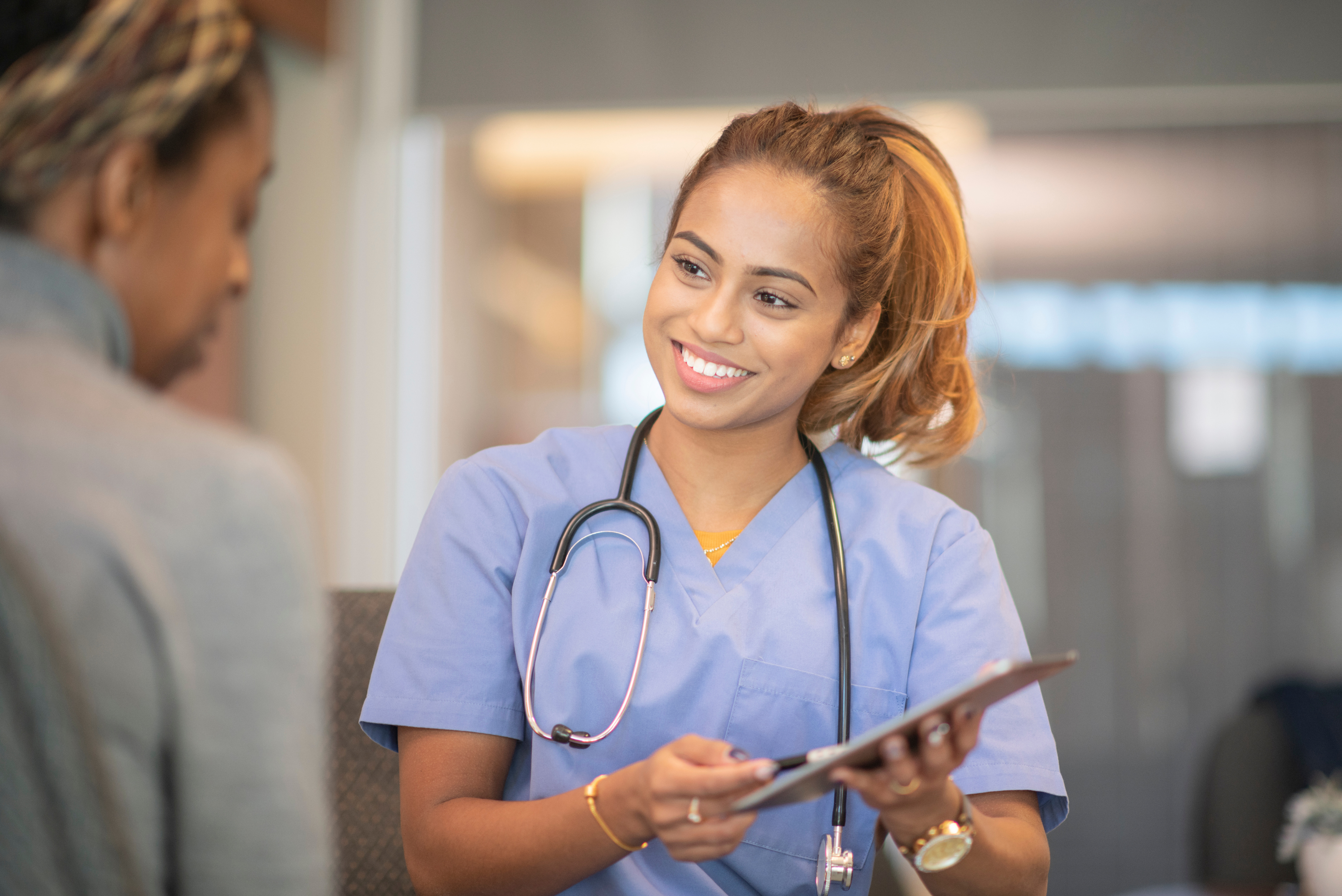 Uśmiechnięta lekarka opowiada o wynikach pacjentce.