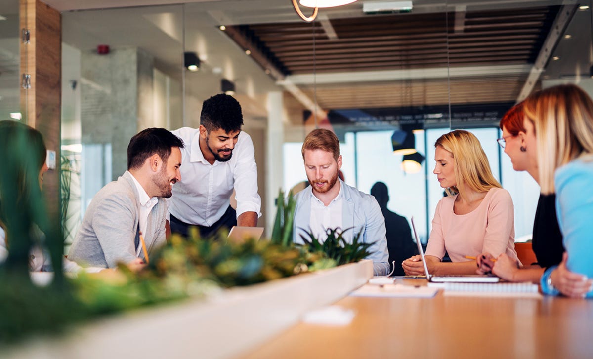 Nauczyciel języka angielskiego prowadzący lekcje angielskiego biznesowego z grupą trzech profesjonalistów
