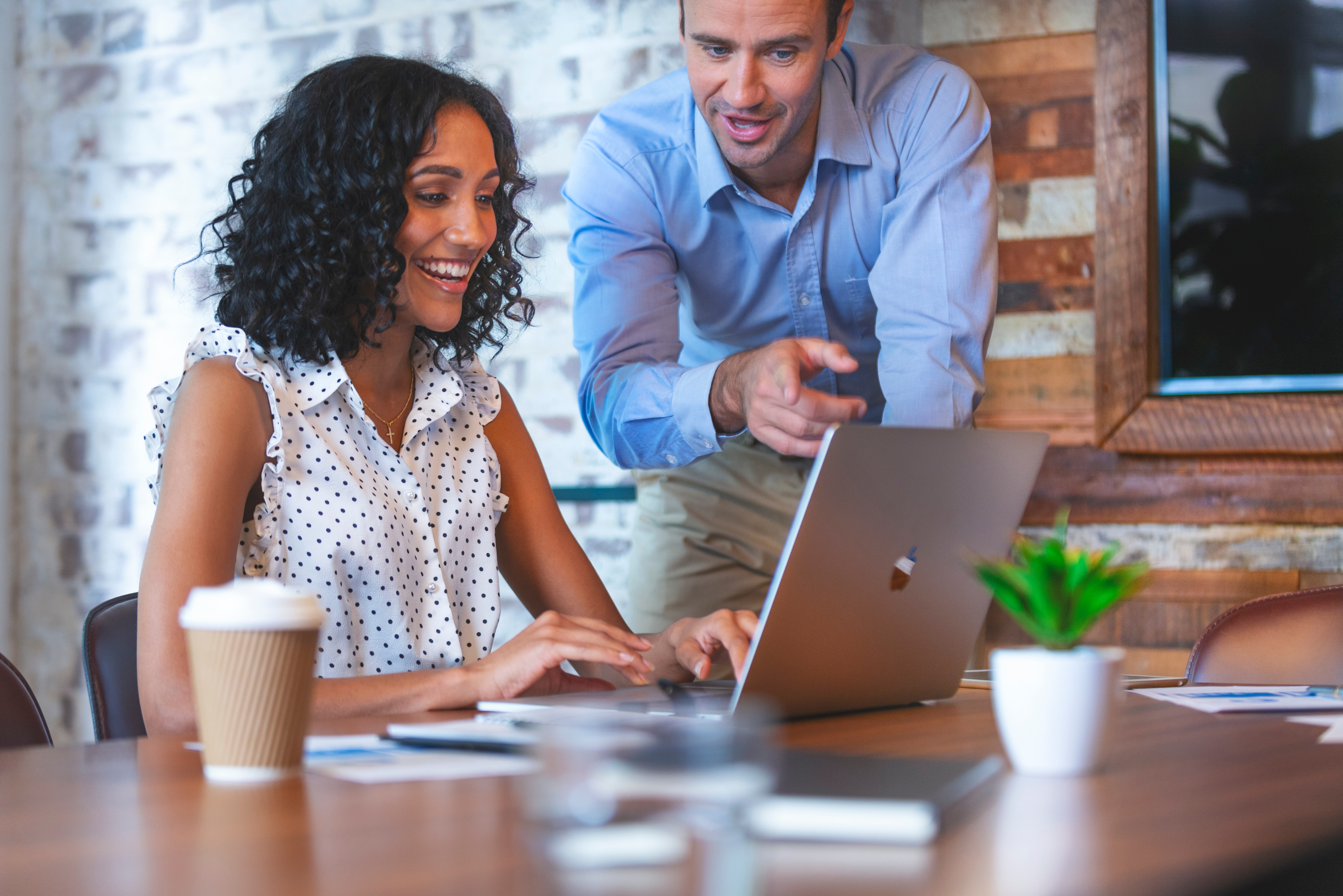 Nauczyciel włoskiego pokazuje coś kobiecie na laptopie.