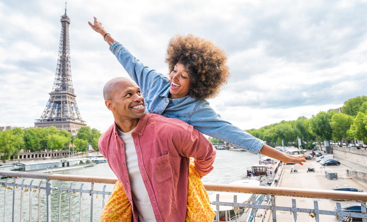 Szczęśliwa para na moście w Paryżu. W tle widać wieżę Eiffla