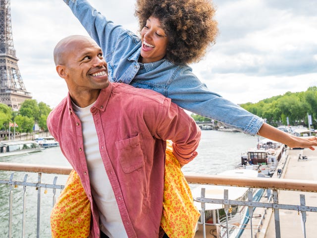 Szczęśliwa para na moście w Paryżu. W tle widać wieżę Eiffla