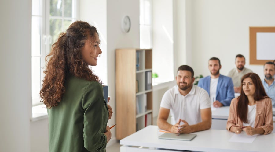 W sali lekcyjnej, grupa dorosłych uczy się języka włoskiego