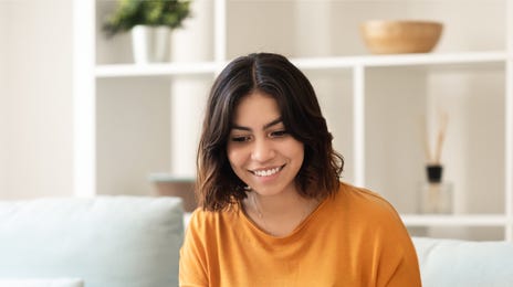 Kobieta siedząca na kanapie, robiąca notatki podczas kursu japońskiego online