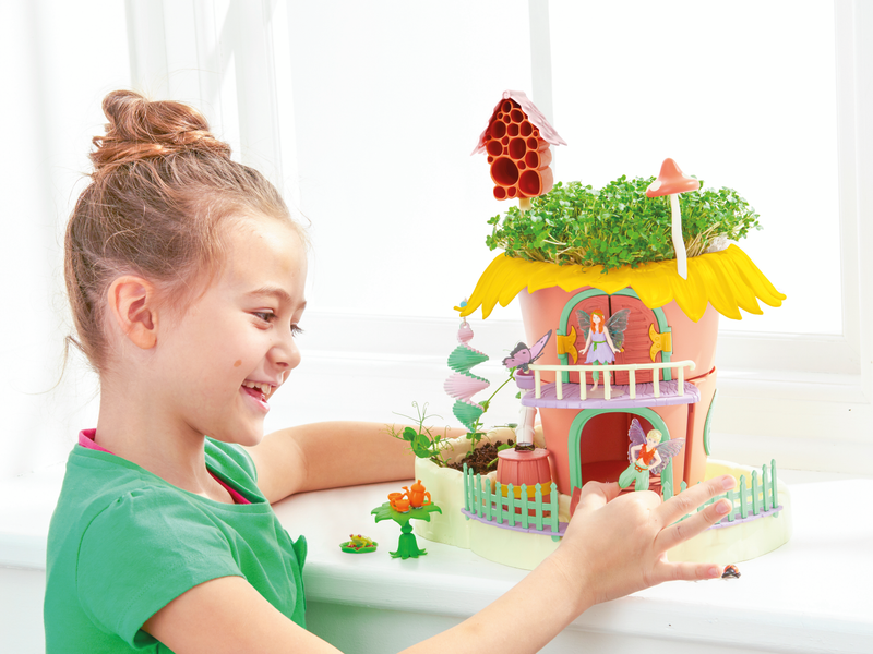 Girl placing a fairy figurine onto her My Fairy Garden Playset.