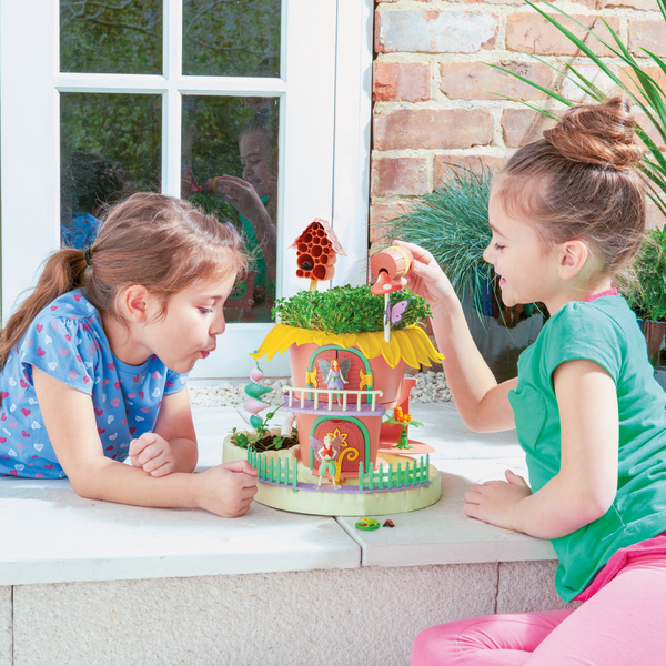 Two girls playing with My Fairy Garden Playset outside.
