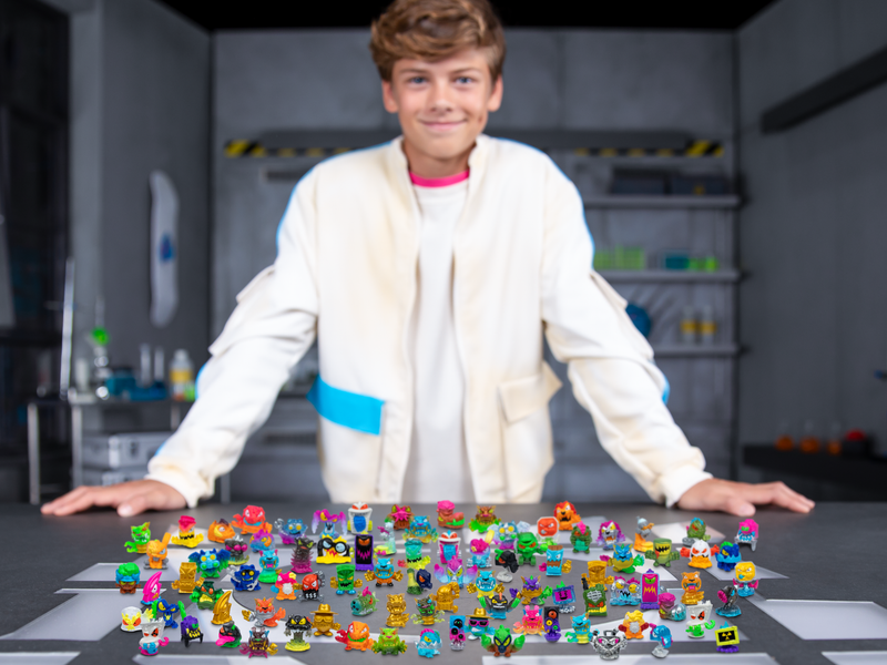 Boy standing behind a collection of over 100 + MrBeast Lab Swarms.