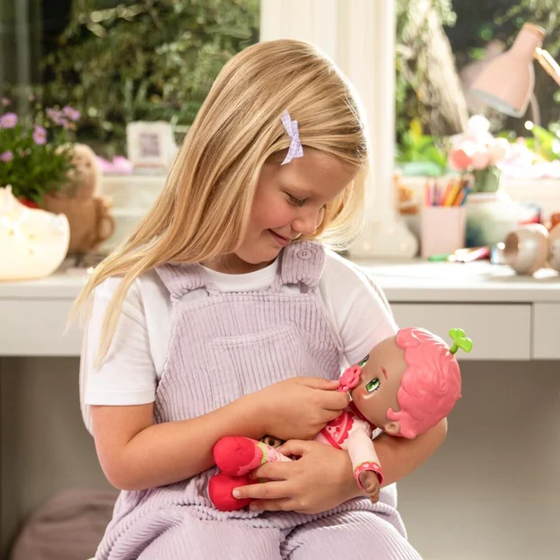 Young girl holding a Luvibubs Doll Single Pack Kind Kira toy in her arms.