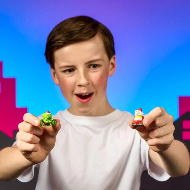 Young boy holding two swarms toys in front of him.