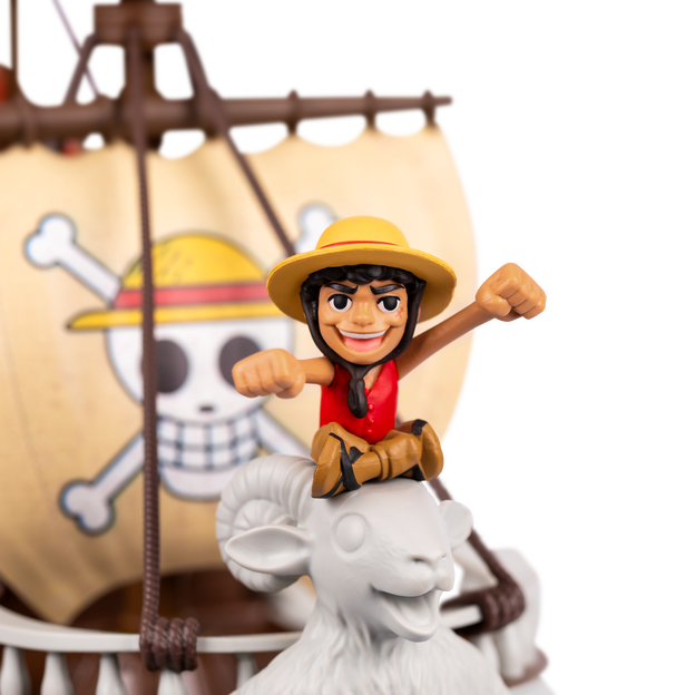 Close up of one piece mini action figure sitting on the front of a ship.