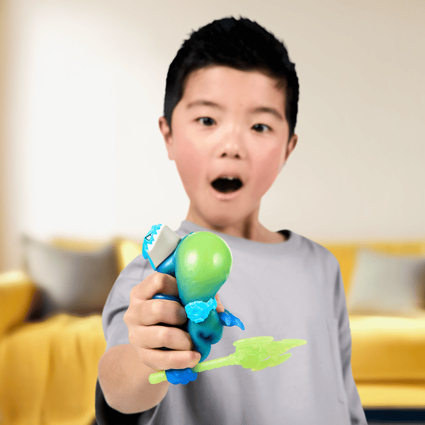 Young boy squeezing a blue Heroes of Goo Jit Zu toy with green filling bursting out.