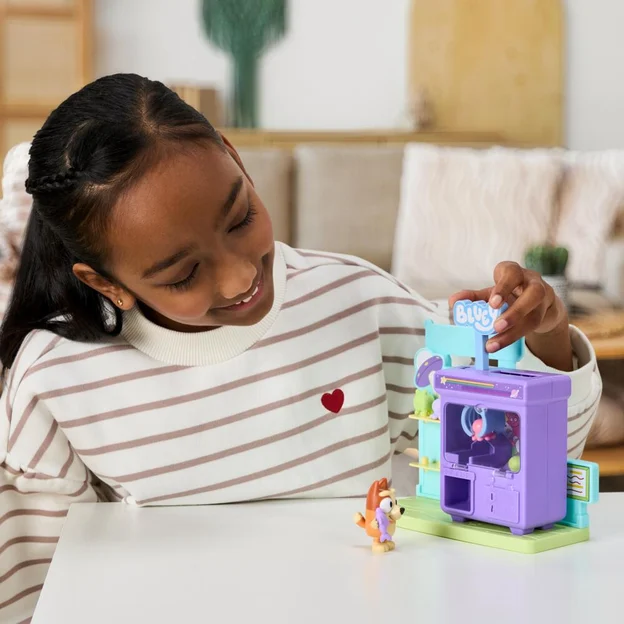 Young girl playing with her Bluey S15 Mini Playset Claw Machine toy.