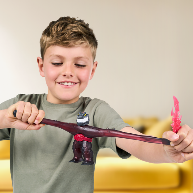 Young boy stretching his Heroes of Goo Jit Zu toy by the arms. 