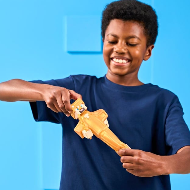 Young boy stretching a Goo Jitzu Minecraft S4 Hero Pack Gold Armor Steve toy.